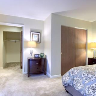 A cozy bedroom with a bed, nightstands, and a walk-in closet.