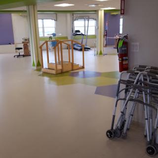 An interior view of a rehabilitation therapy room, equipped with walking aids and designed for accessibility.