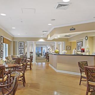 A well-lit dining area featuring multiple tables and chairs, with a clean and modern decor.