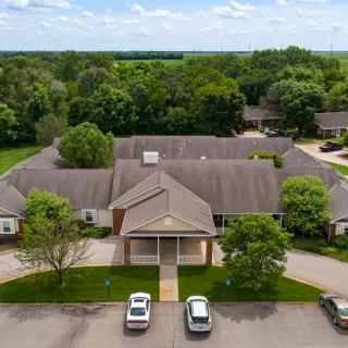 Aerial view of a suburban building with a parking lot surrounded by trees.