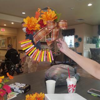 A vibrant autumn-themed wreath adorned with colorful flowers and decorations.