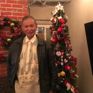 A man stands next to a beautifully decorated Christmas tree, embodying the festive spirit of the season.
