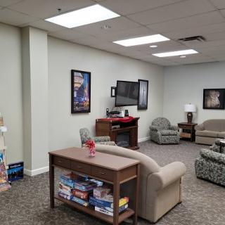 A cozy waiting room with comfortable seating, a television, and reading materials.