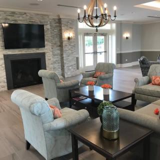 A cozy living room with plush seating, a fireplace, and a chandelier.