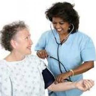 A nurse taking a patient's blood pressure with a stethoscope.