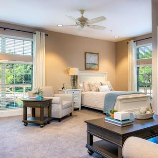 A bright and inviting bedroom featuring comfortable seating and elegant decor.