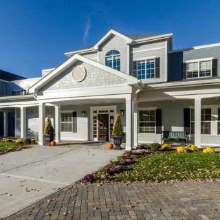 A large suburban house with a landscaped front yard and driveway.
