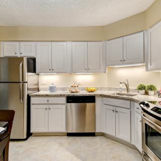 A modern kitchen with stainless steel appliances and white cabinets.