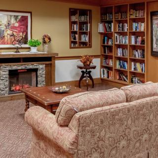 Cozy living room with a fireplace, bookshelves, and comfortable seating.