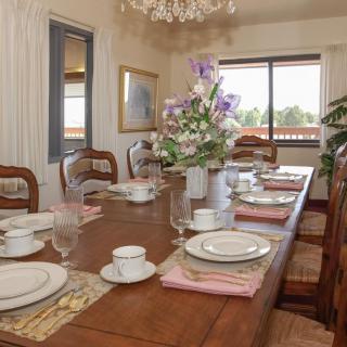 An elegantly set dining table with a floral centerpiece and dinnerware.