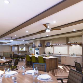 A spacious, modern kitchen with an open dining area, featuring sleek countertops and ceiling fans.