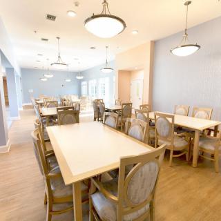 A spacious and bright dining area with tables and chairs arranged in a neat layout.