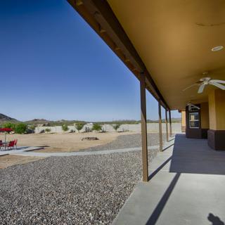 A patio overlooking a desert landscape with clear skies and rocky terrain.
