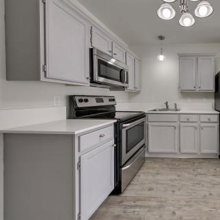 A modern kitchen with white cabinets and stainless steel appliances.