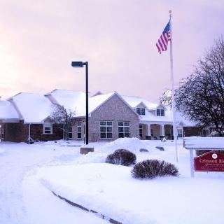 A snow-covered building with an American flag under a winter sunset.