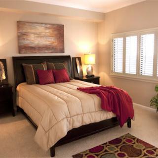 A cozy bedroom interior with a large bed, warm lighting, and decorative elements.