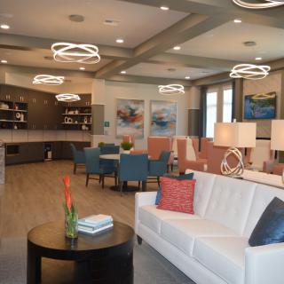 A modern open-concept living room and kitchen area with stylish lighting and comfortable seating.