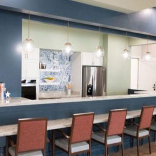 Modern kitchen interior with a long counter and stylish bar stools.