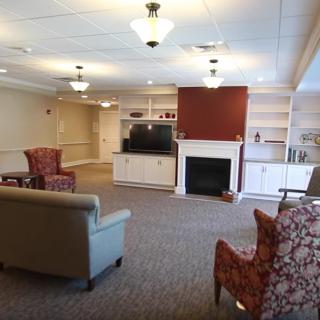 A cozy living room with comfortable seating, a fireplace, and a television.