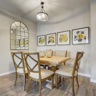 A cozy dining room featuring a wooden table, stylish chairs, and decorative artwork on the walls.