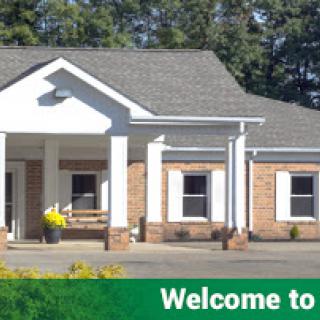 A welcoming entrance to a charming building surrounded by lush greenery.