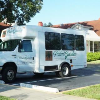 A shuttle bus parked in front of a building with trees in the background.