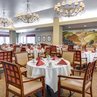 Elegant dining room with neatly arranged tables and stylish chandeliers.