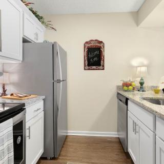 A modern kitchen featuring white cabinets, stainless steel appliances, and tasteful decor.