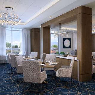 A modern dining area with elegant chandeliers and plush seating.