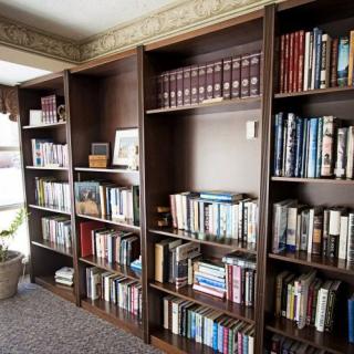 A cozy home library with wooden bookshelves filled with a variety of books.