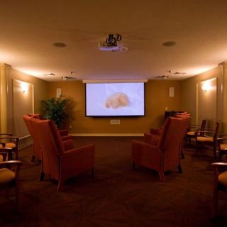 A cozy home theater with comfortable seating arranged around a projection screen.
