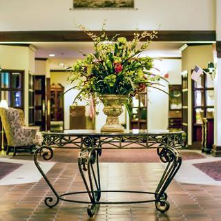 Elegant hotel lobby with a floral arrangement centerpiece.