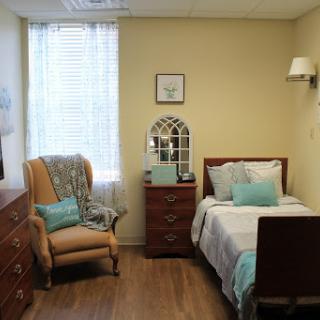 A cozy bedroom featuring a single bed, stylish furniture, and natural light coming through the window.