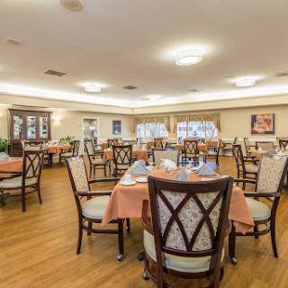 A spacious dining area set up for guests, featuring elegant chairs and neatly arranged tables.