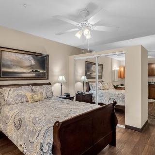 A cozy bedroom with a wooden sleigh bed and mirrored closet doors.