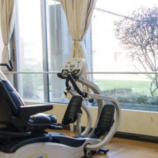 An exercise bike in a well-lit gym with large windows.