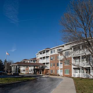 A sunny day view of a modern residential building with balconies and clear skies.