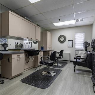 A modern hair salon interior with styling chairs and mirrors.