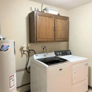 A functional laundry room equipped with a washer, dryer, and storage cabinet.