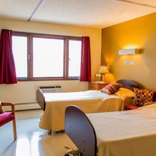 A cozy hospital room featuring two beds and a warm ambiance.