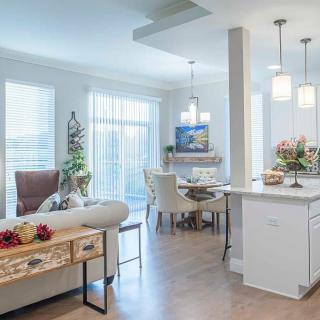 A modern open-concept living space with a dining area and kitchen, featuring bright lighting and stylish decor.