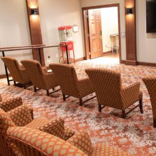 A cozy home theater setup with comfortable seating and a popcorn machine in the corner.