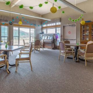 A bright and inviting recreation room with comfortable seating and large windows.