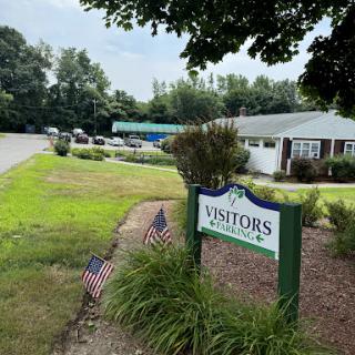 A welcoming visitors center surrounded by greenery and American flags.