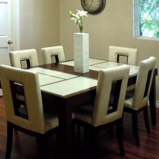 A modern dining room with a wooden table, six upholstered chairs, and a decorative vase centerpiece.