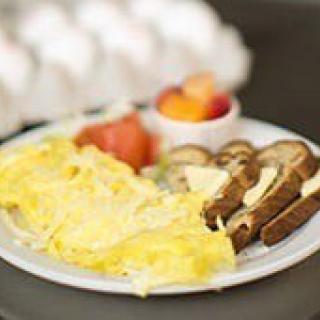 A breakfast plate with an omelette, toast, and fruit.