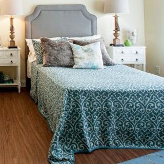 A cozy bedroom with a neatly made bed, two nightstands, and elegant decor.