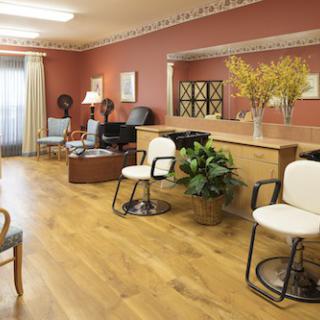 A cozy salon interior with chairs, a waiting area, and hair dryers.
