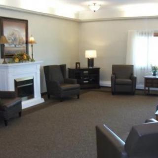 A cozy living room with multiple chairs arranged around a fireplace.
