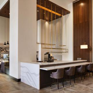 A modern cafe interior with bar seating and contemporary lighting.